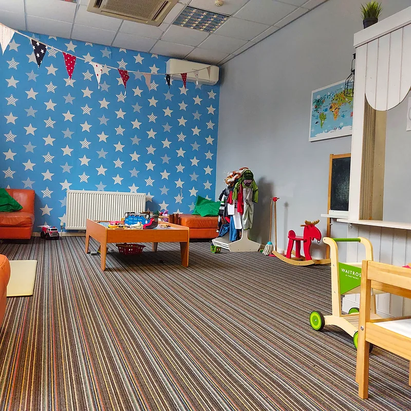 Play area with star wallpaper, bunting and seating