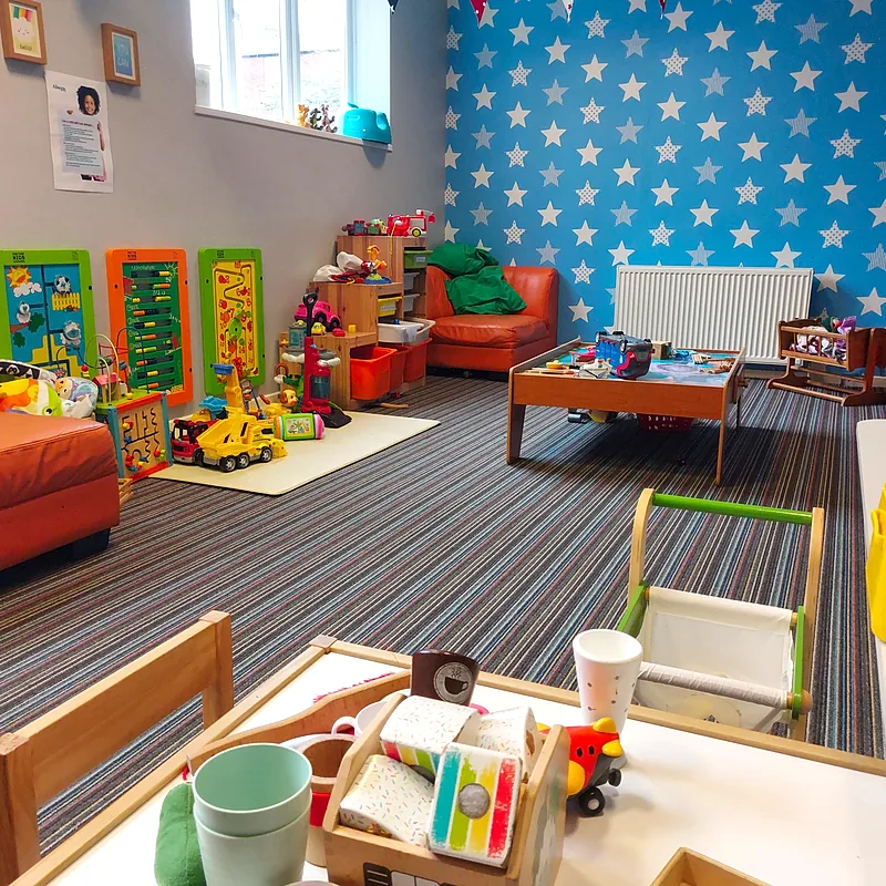 Play area with activity boards, toy kitchen and sofas